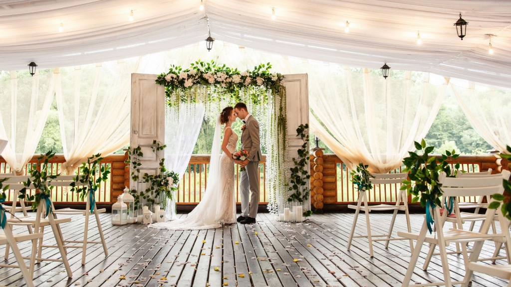 A bride and groom under a wedding arch.